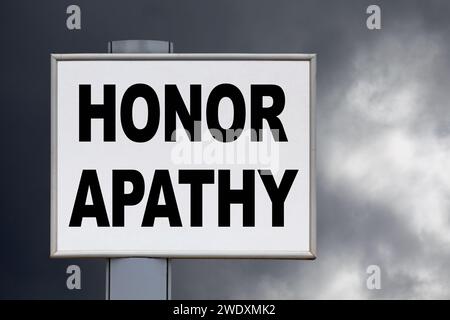 Primo piano su un cartellone giallo contro un cielo nuvoloso con il messaggio "Honor apathy" scritto nel mezzo. Foto Stock