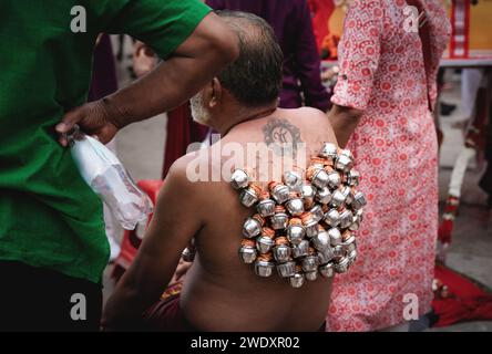 Georgetown, Penang, Malesia - 5 febbraio 2023: Devoto indù con pentole di metallo con offerte agganciate sul retro al festival Thaipusam Foto Stock