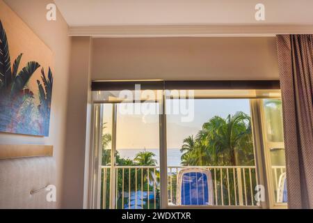 Dalla camera si gode di una splendida vista sulle palme che si affacciano sull'oceano Atlantico attraverso la porta del balcone aperta. Foto Stock