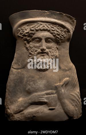 Benaki MuseumQuesto busto in terracotta del Dio greco Dioniso risale al 380-360 a.C. Indossa uno stephane (un tipo di fascia metallica capovolta) nei capelli e tiene un uovo nella mano sinistra e una brocca per il vino sulla destra. Atene Grecia. Foto Stock