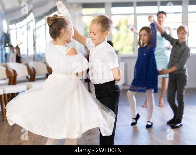 Danze classiche eseguite da bambini preadolescenti in abiti festivi Foto Stock