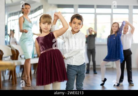 Danze classiche eseguite da bambini preadolescenti in abiti festivi Foto Stock