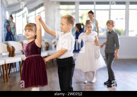 Danze classiche eseguite da bambini preadolescenti in abiti festivi Foto Stock