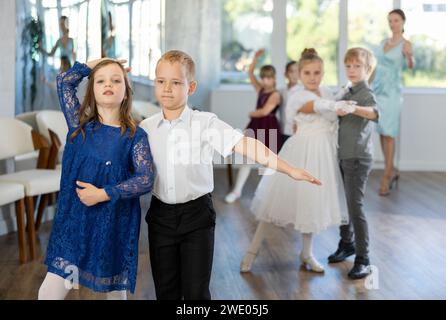 Danze classiche eseguite da bambini preadolescenti in abiti festivi Foto Stock