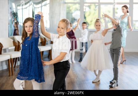 Danze classiche eseguite da bambini preadolescenti in abiti festivi Foto Stock