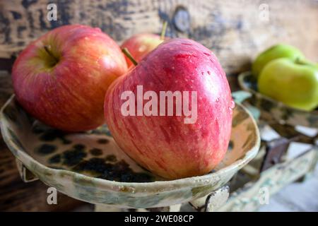 mela rossa su scala e sfondo in legno, stile retrò - vista laterale. Foto Stock