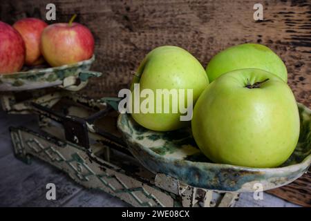 mele verdi e rosse su scala e fondo in legno, stile retrò - vista laterale. Foto Stock