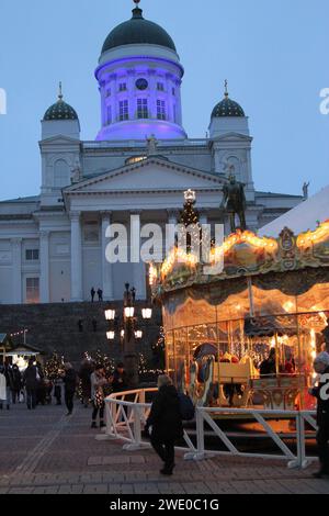 Mercatino di Natale con giostra in Piazza del Senato (Senaatintori), Helsinki, Finlandia, 5 dicembre 2017. L'illuminazione blu e bianca ha celebrato i 100 anni di indipendenza della Finlandia il 6 dicembre 2017. Foto Stock