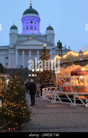 Mercatino di Natale con giostra in Piazza del Senato (Senaatintori), Helsinki, Finlandia, 5 dicembre 2017. L'illuminazione blu e bianca ha celebrato i 100 anni di indipendenza della Finlandia il 6 dicembre 2017. Foto Stock