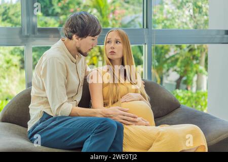 La donna in attesa si sente male, il marito la conforta e la rassicura durante una gravidanza impegnativa Foto Stock