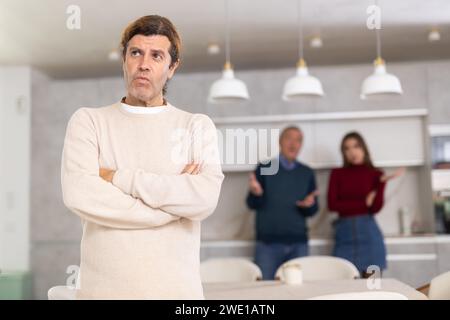 Padre e moglie rimproverano un uomo. Non vuole parlare con loro. Litigio familiare Foto Stock