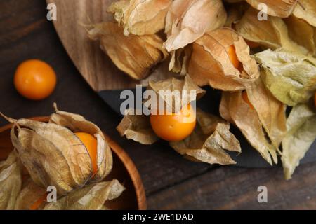 Frutti di physalis maturi con calici su tavola in legno, spianata Foto Stock