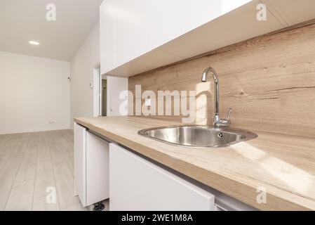 una piccola cucina a vista arredata e senza elettrodomestici in una casa tipo loft Foto Stock