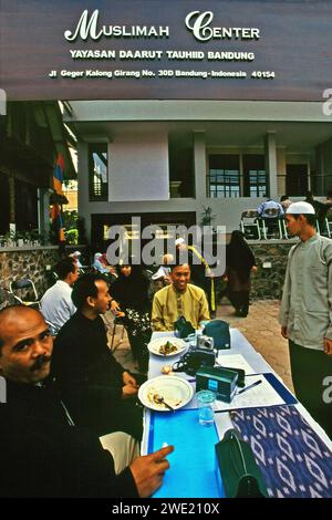 Le persone, alcune di loro sono turisti religiosi, vengono fotografate mentre sono sedute e hanno conversazioni di fronte al "centro per donne musulmane", edificio gestito dalla fondazione Daarut Tauhiid a Bandung, Giava Occidentale, Indonesia. Fondata da un famoso predicatore islamico indonesiano KH Abdullah Gymnastiar, dal collegio e dalla fondazione Daarut Tauhiid, insieme al suo marchio di attività Manajemen Qolbu (mq), sono riusciti a intensificare il turismo religioso e le attività economiche nell'area di Gegerkalong nella città di Bandung. Foto Stock