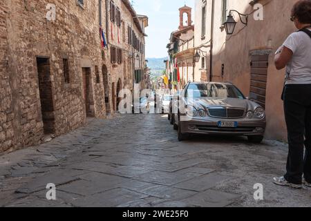 Gubbio Italia - 12 maggio 2011; stretta strada murata in pietra nella città medievale italiana dove le auto parcheggiate lasciano poco spazio. Foto Stock