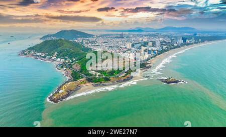 Vista aerea della città di Vung Tau con un bellissimo tramonto e tante barche. Vista panoramica della costa di Vung Tau dall'alto, con onde, costa, strade Foto Stock