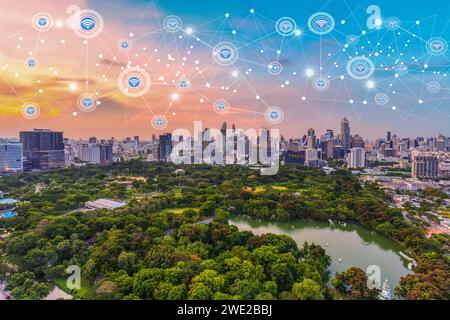 Città moderna al crepuscolo con concetto di comunicazione wireless con connessione di rete Foto Stock