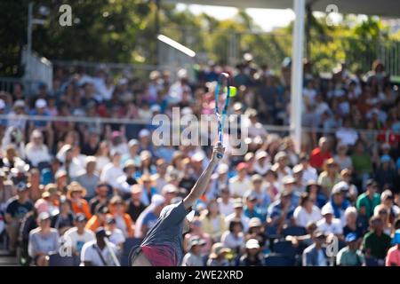 giocare a tennis su un campo blu. serve in un campo da tennis con una folla di tifosi che guardano Foto Stock