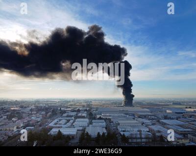 Veduta aerea del maggiore incendio nell'industria di Cavenago di Brianza, vicino a Milano, Italia. Incendio doloso nella città italiana. Nubi tossiche di fumo nero (22 gennaio 2024) Foto Stock