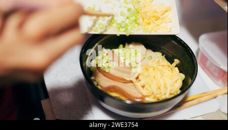 Giapponese, ramen e cibo nel ristorante con cipolla e ingredienti primaverili, bacchette e abilità dello chef con decorazioni. Cucina tradizionale a persona Foto Stock