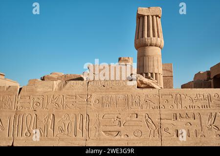 Luxor, Egitto - dicembre 26 2023: Rovine del tempio di Karnak. Pareti in pietra con disegni scolpiti, geroglifici e testa di colonna egiziana Foto Stock