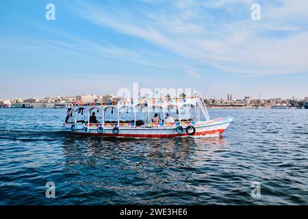 Luxor, Egitto - dicembre 26 2023: Barche a motore per attraversare il Nilo dall'altra parte, trasporto fluviale ornato Foto Stock