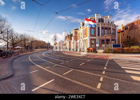 Amsterdam Street invernale, bandiera olandese contro case tipiche, Olanda, Paesi Bassi. Foto Stock