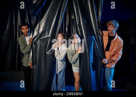 gruppo di giovani multiculturali impegnati in un'emozionante sfida nella escape room, avventura al coperto Foto Stock