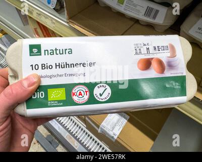 Baviera, Germania - 13 gennaio 2024: Un uomo tiene una scatola di uova biologiche in un supermercato *** Ein Mann hält eine Packung Bio Eier in einem Supermarkt Foto Stock