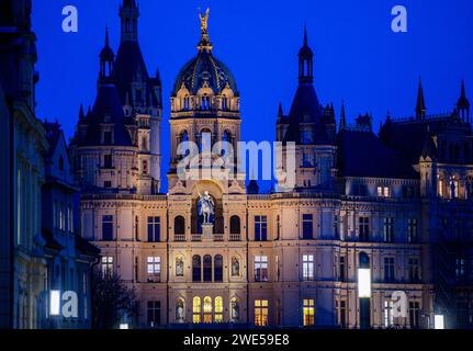 Schwerin, Germania. 23 gennaio 2024. La cupola dorata del castello di Schwerin è illuminata di sera. Il castello fu la residenza dei duchi e granduchi del Meclemburgo per secoli ed è ora la sede del parlamento statale del Meclemburgo-Vorpommern. Credito: Jens Büttner/dpa/Alamy Live News Foto Stock