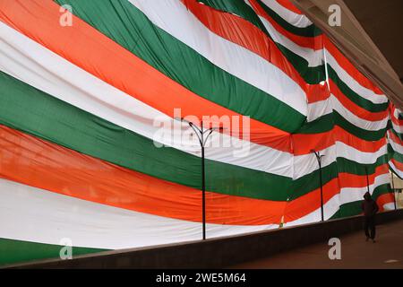 Srinagar, India. 23 gennaio 2024. 23 gennaio 2024, Srinagar Kashmir, India: Un uomo cammina davanti a un gigantesco tricolore indiano a Srinagar. La Festa della Repubblica in India commemora l'adozione della costituzione e la transizione del paese a una Repubblica il 26 gennaio 1950, con celebrazioni che si svolgono ogni anno nella stessa data. Il 23 gennaio 2024, Srinagar Kashmir, India. (Foto di Firdous Nazir/Eyepix Group) credito: SIPA USA/Alamy Live News Foto Stock