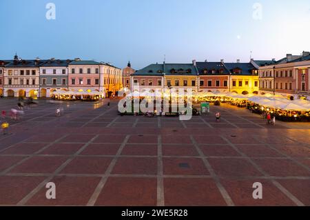 Rynek Wielki con caffetterie e ristoranti di strada alla luce della sera a Zamość, nel voivodato di Lubelskie in Polonia Foto Stock