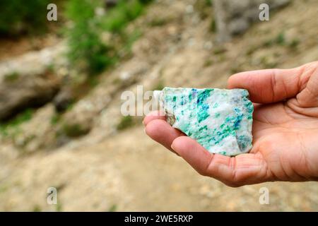 Donna in possesso di pietra con malachite e azurite in mano, estrazione del rame, Gratlspitze, Wildschönau, Alpi di Kitzbühel, Tirolo, Austria Foto Stock