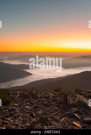 Pittoresco paesaggio montano all'alba con bassa nebbia fitta in una valle di montagna Foto Stock