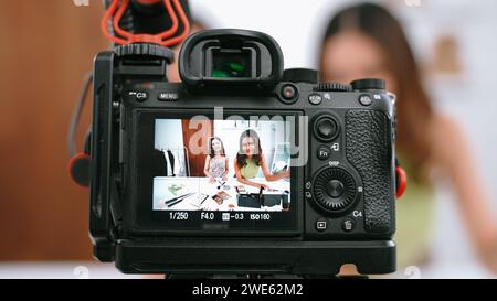 La vista posteriore mostra lo schermo della telecamera due donne influencer girano in live streaming vlog recensione video trucco social media o blog. Ragazza con cosmetici Foto Stock
