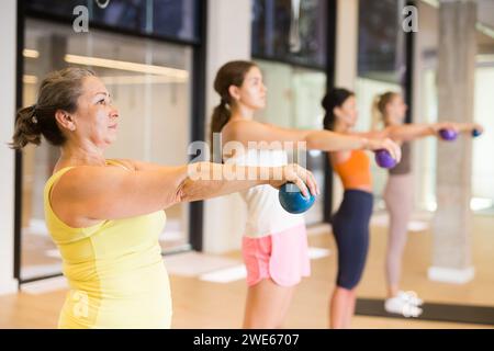 Maturo femmina esecuzione serie di esercizi con pilates palla Foto Stock