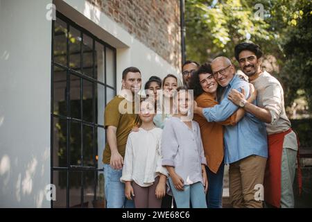 Gruppo eterogeneo di membri della comunità che abbracciano un progetto comunitario di successo Foto Stock