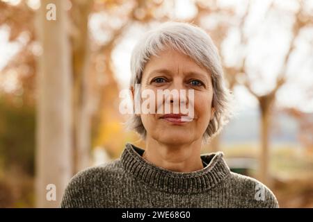 Donna matura sorridente con capelli grigi corti Foto Stock