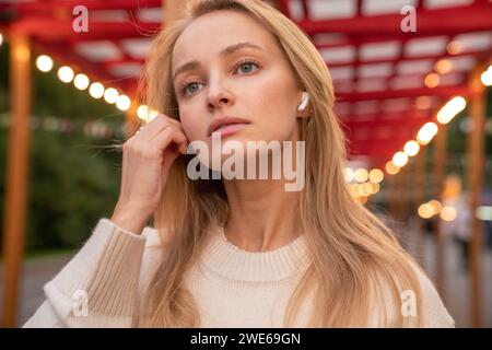 Bella donna che indossa cuffie intrauricolari wireless Foto Stock