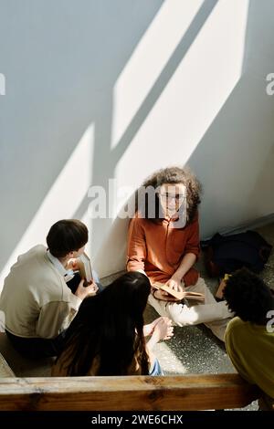 Studenti seduti a discutere al piano dell'università Foto Stock