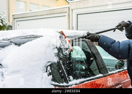 Pulizia della neve dal parabrezza. Pulizia e pulizia dell'auto dalla neve in un giorno d'inverno. Foto Stock