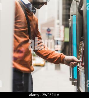 Giovane uomo d'affari che usa il bancomat Foto Stock