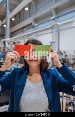 Donna d'affari che copre gli occhi con pezzi di legno nell'industria Foto Stock