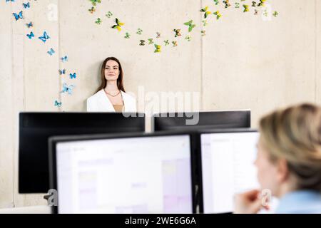 Giovane apprendista premuroso che si trova di fronte al muro sul posto di lavoro Foto Stock