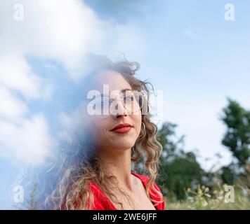 Giovane donna con capelli ricci che indossa occhiali da vista Foto Stock