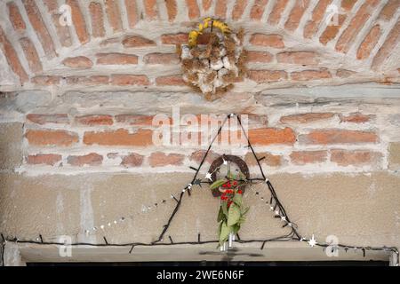 259 simboli popolari: Foglie e frutti di bosco, ferro di cavallo e corde d'aglio adornano porte e finestre della casa, area del vecchio Bazaar. Korca-Albania. Foto Stock