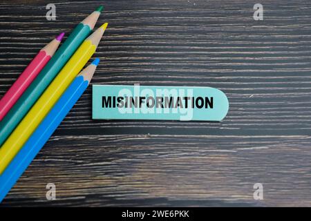 Concetto di disinformazione scrivere su foglietti adesivi isolati su tavola di legno. Foto Stock