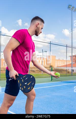 Ritratto di un giovane che gioca a Pickleball. Giovane che sta per eseguire il punto di servizio in picchettino Foto Stock