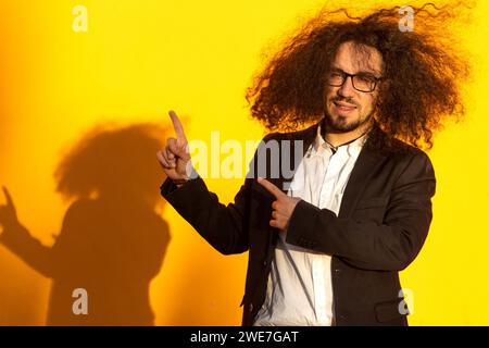 Uomo con capelli lunghi che puntano ad un oggetto davanti a lui Foto Stock
