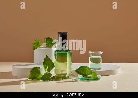 Diversi podi visualizzati con un flacone di etichetta vuoto. Liquido verde contenuto all'interno di un becher e di una piastra di Petri. Mockup del prodotto cosmetico estratto da Foto Stock